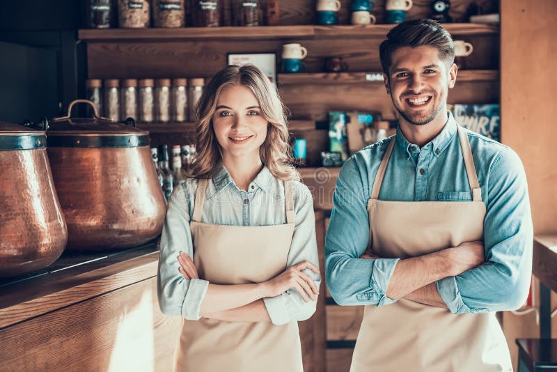 Πορτρέτο δύο baristas στις ποδιές στη καφετερία στοκ εικόνες Πορτρέτο δύο baristas στις ποδιές στη καφετερία στοκ εικόνες