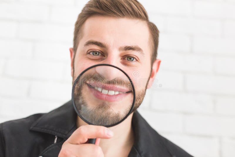 Πορτρέτο ενός ατόμου με έναν πιό magnifier σε ένα άσπρο υπόβαθρο στοκ εικόνες Πορτρέτο ενός ατόμου με έναν πιό magnifier σε ένα άσπρο υπόβαθρο στοκ εικόνες