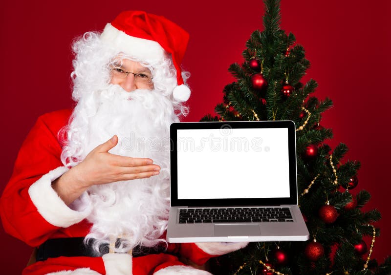 Πορτρέτο ενός ευτυχούς lap-top εκμετάλλευσης santa στοκ εικόνα με δικαίωμα ελεύθερης χρήσης Πορτρέτο ενός ευτυχούς lap-top εκμετάλλευσης santa στοκ εικόνα με δικαίωμα ελεύθερης χρήσης