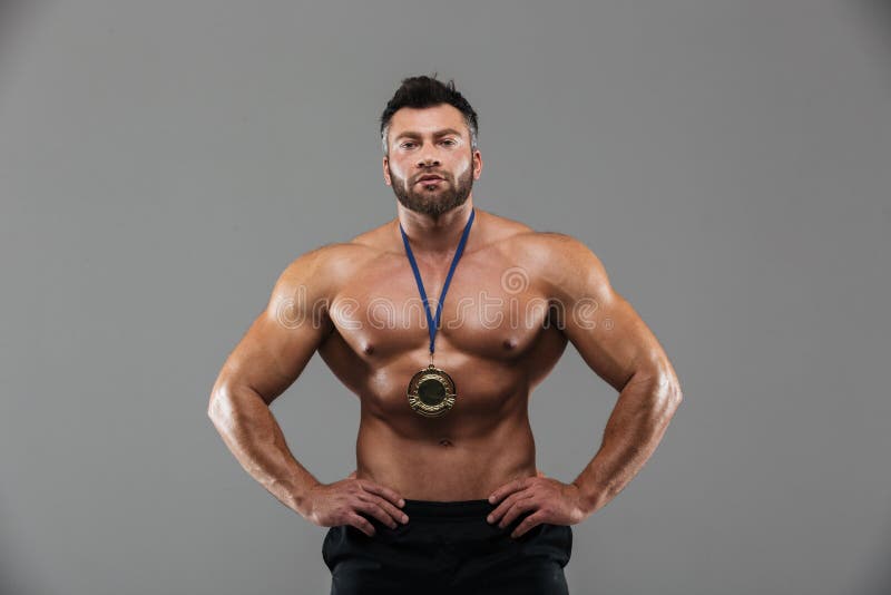 Πορτρέτο ενός κατάλληλου ικανοποιημένου αρσενικού γυμνοστήθων bodybuilder που θέτει