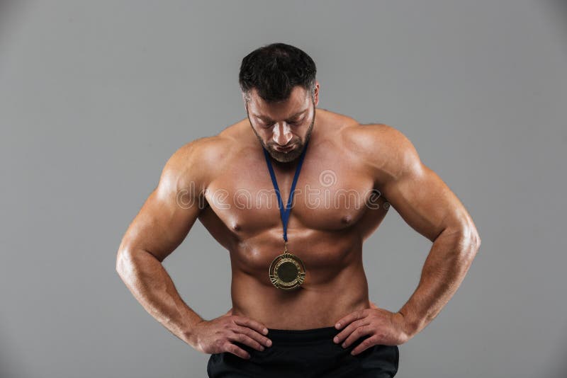 Πορτρέτο ενός κατάλληλου ισχυρού αρσενικού γυμνοστήθων bodybuilder που θέτει