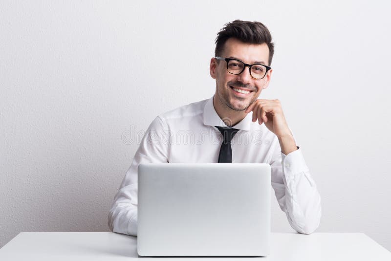 Πορτρέτο ενός νεαρού άνδρα με το lap-top σε ένα στούντιο, εργασία στοκ εικόνα με δικαίωμα ελεύθερης χρήσης Πορτρέτο ενός νεαρού άνδρα με το lap-top σε ένα στούντιο, εργασία στοκ εικόνα με δικαίωμα ελεύθερης χρήσης