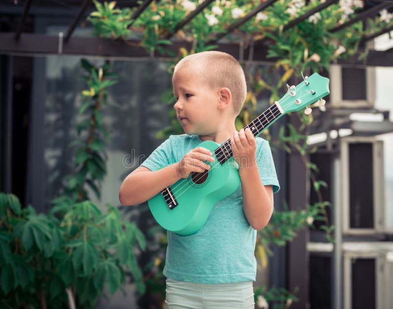 Πορτρέτο ενός χαριτωμένου αγοριού με το ukulele στοκ εικόνα με δικαίωμα ελεύθερης χρήσης Πορτρέτο ενός χαριτωμένου αγοριού με το ukulele στοκ εικόνα με δικαίωμα ελεύθερης χρήσης