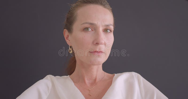 Πορτρέτο κινηματογραφήσεων σε πρώτο πλάνο της ανώτερης καυκάσιας γυναίκας brunette που εξετάζει τη συνεδρίαση καμερών στην πολυθρ