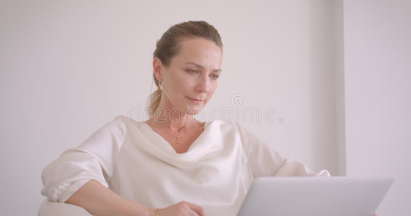 Πορτρέτο κινηματογραφήσεων σε πρώτο πλάνο της ηλικιωμένης καυκάσιας επιχειρηματία brunette που χρησιμοποιεί το lap-top που εξετάζ