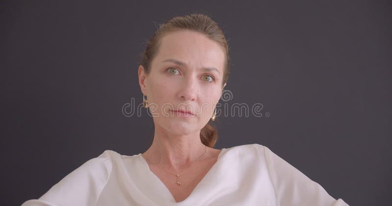Πορτρέτο κινηματογραφήσεων σε πρώτο πλάνο της ηλικιωμένης καυκάσιας γυναίκας brunette που εξετάζει τη συνεδρίαση καμερών στην πολ