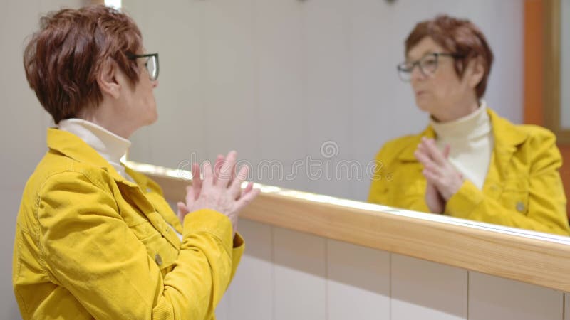 Πορτρέτο μιας ηλικιωμένης γυναίκας μπροστά από έναν καθρέφτη φιλμ μικρού μήκους
