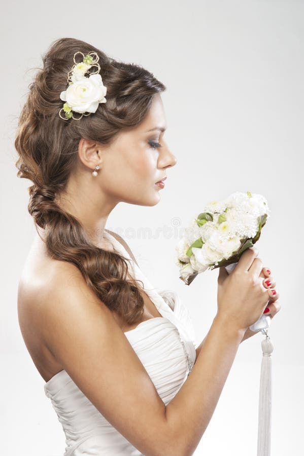 Πορτρέτο μιας νέας νύφης που κρατά τα άσπρα τριαντάφυλλα