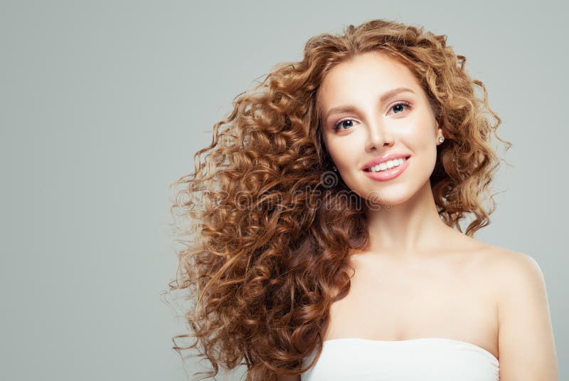 Πορτρέτο ομορφιάς μόδας της νέας redhead γυναίκας με το μακροχρόνιο υγιές σγουρό γκρίζο υπόβαθρο τρίχας στοκ φωτογραφία με δικαίωμα ελεύθερης χρήσης Πορτρέτο ομορφιάς μόδας της νέας redhead γυναίκας με το μακροχρόνιο υγιές σγουρό γκρίζο υπόβαθρο τρίχας στοκ φωτογραφία με δικαίωμα ελεύθερης χρήσης
