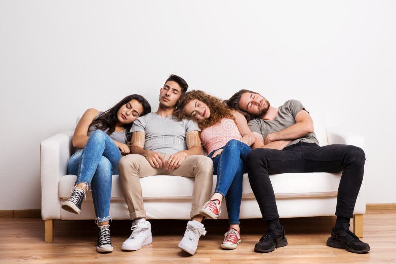Portrait of young group of tired friends sitting on a sofa in a studio, sleeping. Portrait of young group of tired friends sitting on a sofa in a studio, sleeping.