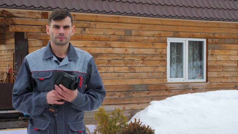 Πορτρέτο του εργαζομένου του σπιτιού που πραγματοποιεί μια επιθεώρηση από θερμικό imager Για να ψάξουν τις απώλειες