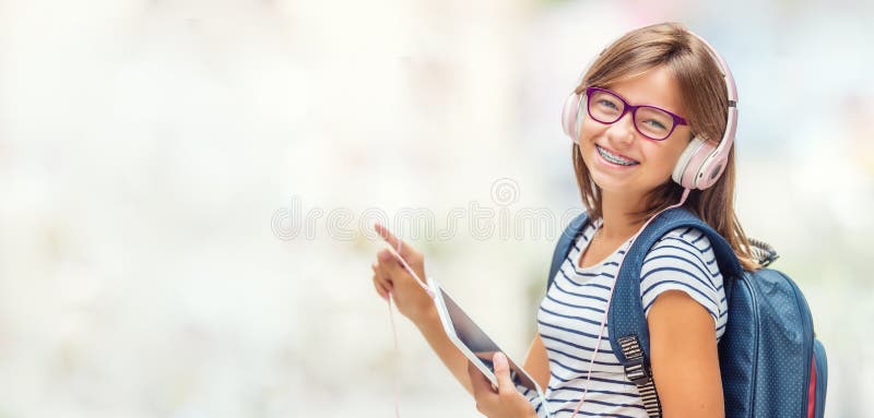 Πορτρέτο του σύγχρονου ευτυχούς σχολικού κοριτσιού εφήβων με το κεφάλι σακιδίων πλάτης τσαντών στοκ εικόνες με δικαίωμα ελεύθερης χρήσης Πορτρέτο του σύγχρονου ευτυχούς σχολικού κοριτσιού εφήβων με το κεφάλι σακιδίων πλάτης τσαντών στοκ εικόνες με δικαίωμα ελεύθερης χρήσης