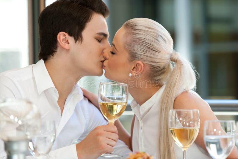 Χαριτωμένο φίλημα ζευγών στον πίνακα γευμάτων. στοκ φωτογραφία με δικαίωμα ελεύθερης χρήσης