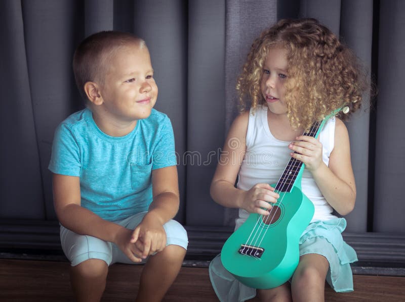 Πορτρέτο χαριτωμένα παιδιά με το ukulele στοκ φωτογραφία με δικαίωμα ελεύθερης χρήσης Πορτρέτο χαριτωμένα παιδιά με το ukulele στοκ φωτογραφία με δικαίωμα ελεύθερης χρήσης