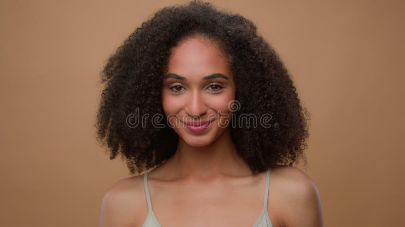 πορτραίτο στο στούντιο μπεζ φόντο διαφημίσεις σκηνικό κοροϊδεύουν την όμορφη αφρικανή γυναίκα νέα