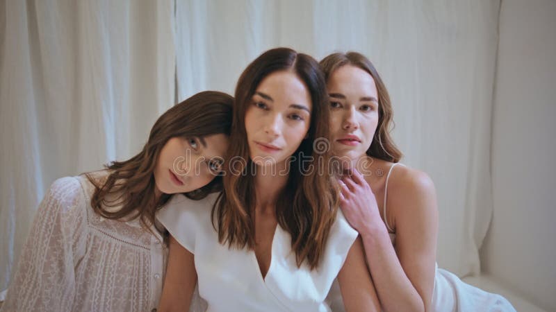 πορτραίτο τρία κορίτσια μαζί κοιτάζοντας κάμερα. γαλήνη πανέμορφες κυρίες αγκαλιάζουν