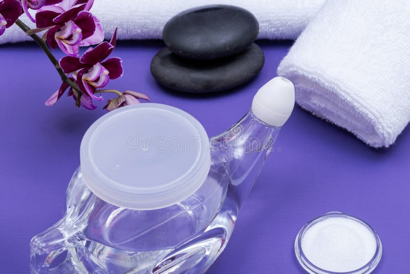 Πορφυρό υπόβαθρο SPA με το δοχείο Neti, σωρός των αλατούχων, κυλημένων επάνω άσπρων πετσετών, των συσσωρευμένων πετρών βασαλτών κ στοκ φωτογραφία Πορφυρό υπόβαθρο SPA με το δοχείο Neti, σωρός των αλατούχων, κυλημένων επάνω άσπρων πετσετών, των συσσωρευμένων πετρών βασαλτών κ στοκ φωτογραφία