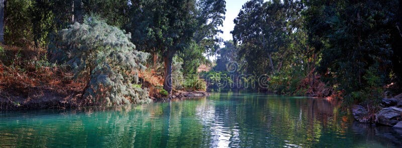 Jordan river with sky, clouds, panorama and green, trees, beautiful, sun with reflection, shrine. Jordan river with sky, clouds, panorama and green, trees, beautiful, sun with reflection, shrine
