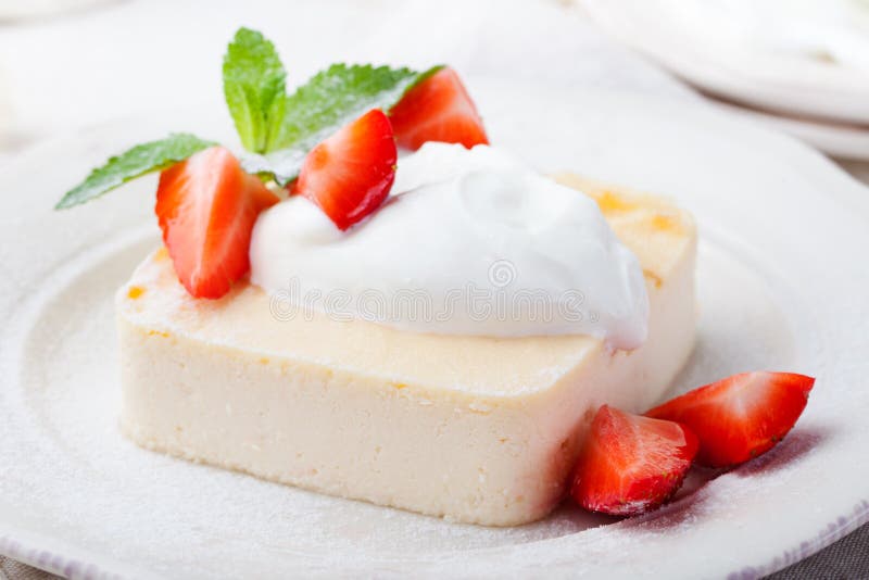 Πουτίγκα, cheesecake, επιδόρπιο κρέμας, με την ξινή κρέμα και τα φρέσκα φύλλα φραουλών και μεντών στοκ εικόνα Πουτίγκα, cheesecake, επιδόρπιο κρέμας, με την ξινή κρέμα και τα φρέσκα φύλλα φραουλών και μεντών στοκ εικόνα