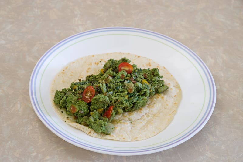 Green eggs and vegetables on a flour tortilla. Green eggs and vegetables on a flour tortilla