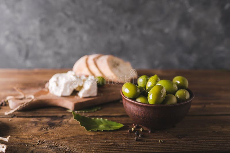 Πράσινες ελιές, τεμαχισμένο ciabatta, τυρί φέτας σε έναν ξύλινο πίνακα καρυκευμένος Τυρί φέτα στοκ εικόνες με δικαίωμα ελεύθερης χρήσης Πράσινες ελιές, τεμαχισμένο ciabatta, τυρί φέτας σε έναν ξύλινο πίνακα καρυκευμένος Τυρί φέτα στοκ εικόνες με δικαίωμα ελεύθερης χρήσης