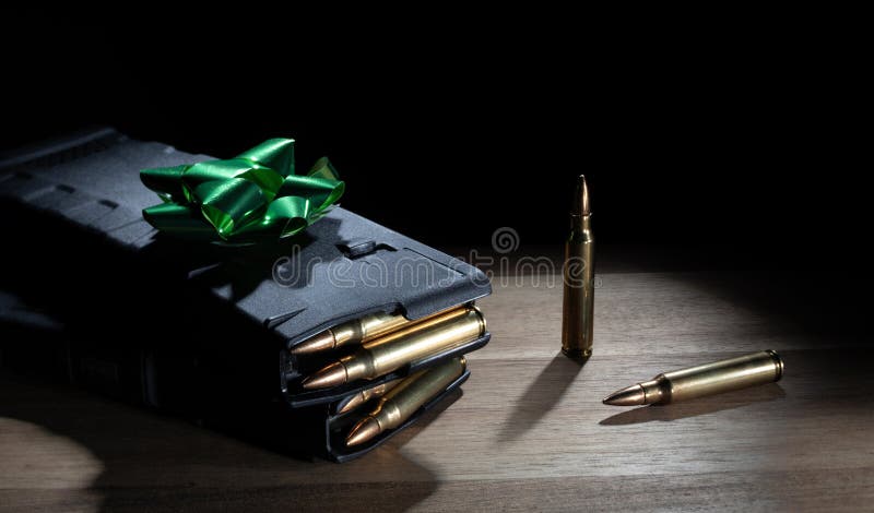 Fully loaded high capacity AR-15 magazines on a table as a gift with a green bow on top. Fully loaded high capacity AR-15 magazines on a table as a gift with a green bow on top