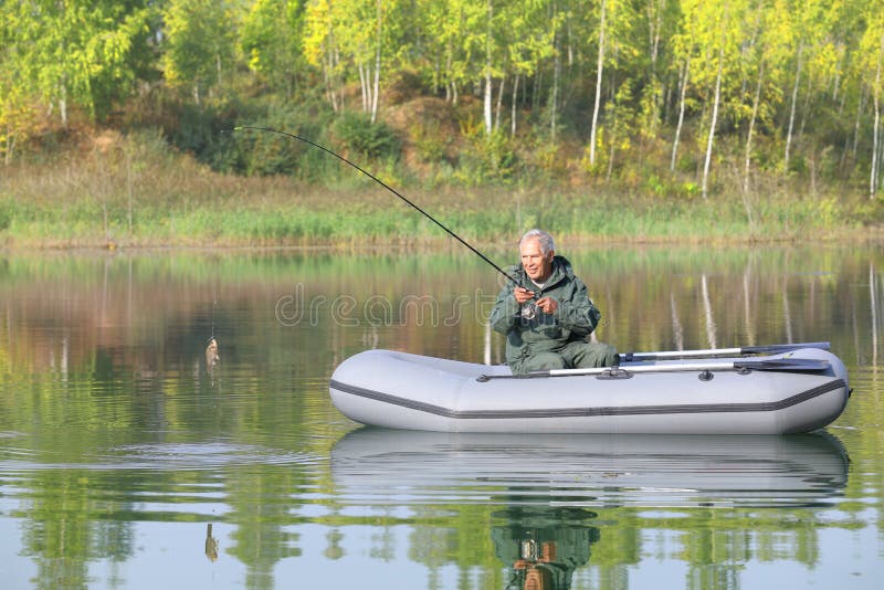 Πρεσβύτερος που αλιεύει από τη βάρκα του μια ηλιόλουστη ημέρα φθινοπώρου