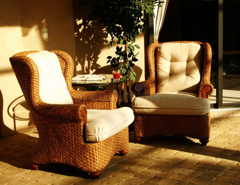 Two wicker lounging chairs in bright sunshine. Two wicker lounging chairs in bright sunshine