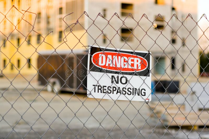 Warning Sign on a Fence Around a Construction Site. Warning Sign on a Fence Around a Construction Site