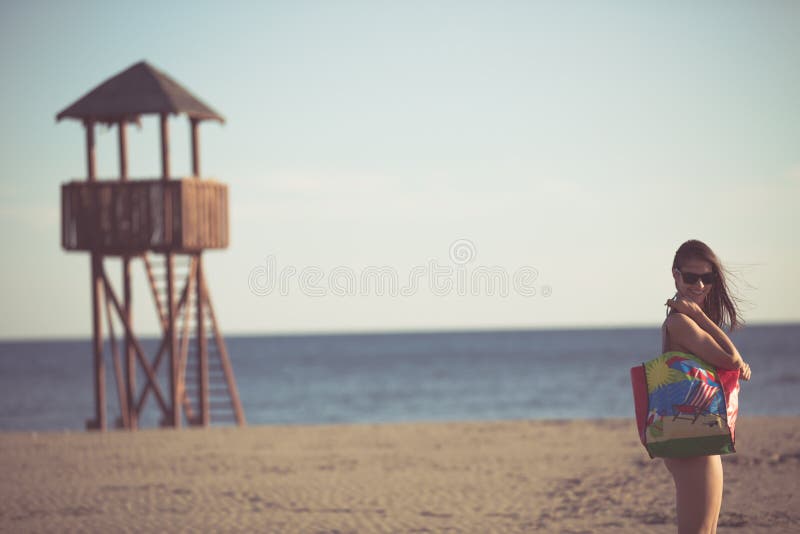 Προκλητική γυναίκα στις διακοπές παραλιών με τα εξαρτήματα Εξάρτημα παραλιών Μετάβαση στις αμμώδεις διακοπές παραλιών Ύφος μόδας