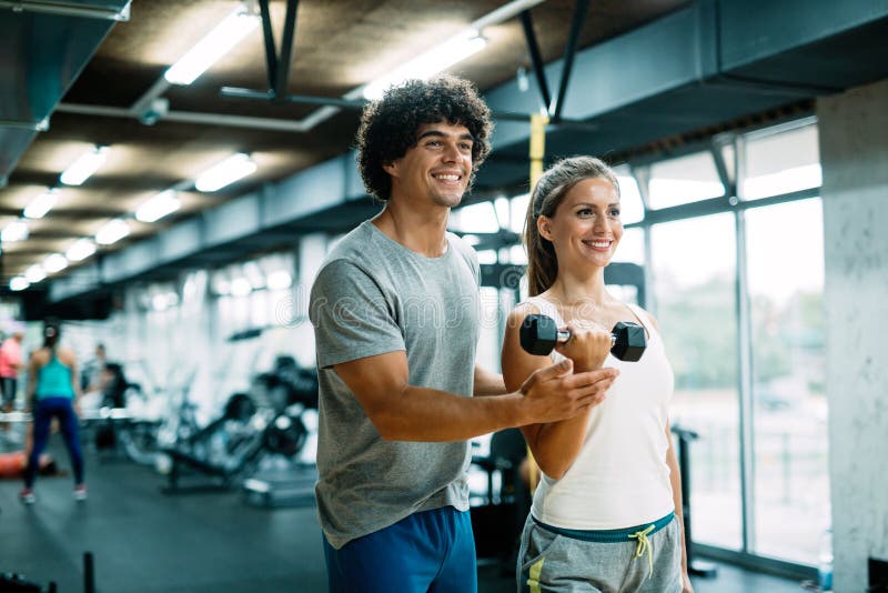 Personal trainer helping women reach goals in gym. Personal trainer helping women reach goals in gym