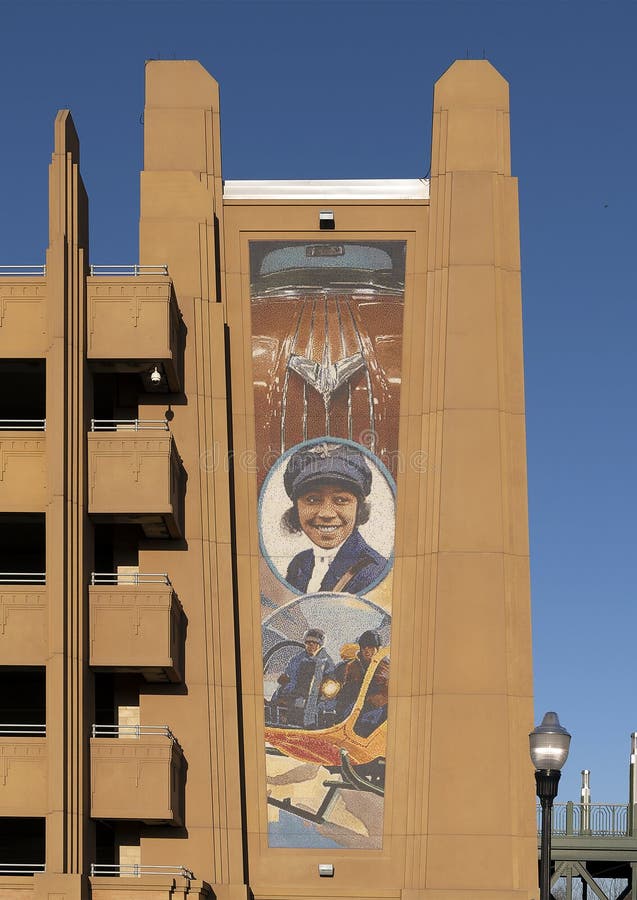 Pictured is `Pioneers of Texas Transportation`, a mosaic tile mural by Mike Mandrel on the Dickies Arena Parking Garage in Fort Worth, Texas.  The central feature of the mural is Elizabeth `Bessie` Coleman, the first African American female pilot.  She was born in 1892 and died in 1926.  She is flanked above by an image of a 1954 Pontiac Chieftain and below by the legendary Bell 47G2 helicopter.  The mural is public art of Fort Worth and is 50 feet high. Pictured is `Pioneers of Texas Transportation`, a mosaic tile mural by Mike Mandrel on the Dickies Arena Parking Garage in Fort Worth, Texas.  The central feature of the mural is Elizabeth `Bessie` Coleman, the first African American female pilot.  She was born in 1892 and died in 1926.  She is flanked above by an image of a 1954 Pontiac Chieftain and below by the legendary Bell 47G2 helicopter.  The mural is public art of Fort Worth and is 50 feet high.