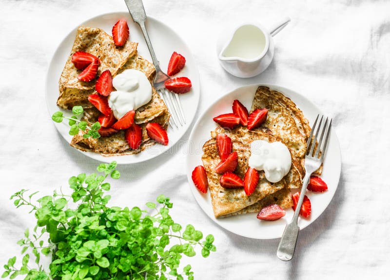 Πρόγευμα, πίνακας επιδορπίων - crepes με τις φράουλες και την κρέμα σε ένα άσπρο υπόβαθρο, τοπ άποψη στοκ εικόνες