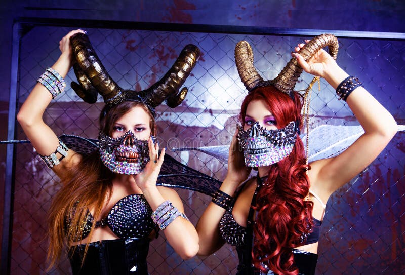 Beautiful young models wearing Halloween costume of leather and horns. Beautiful young models wearing Halloween costume of leather and horns