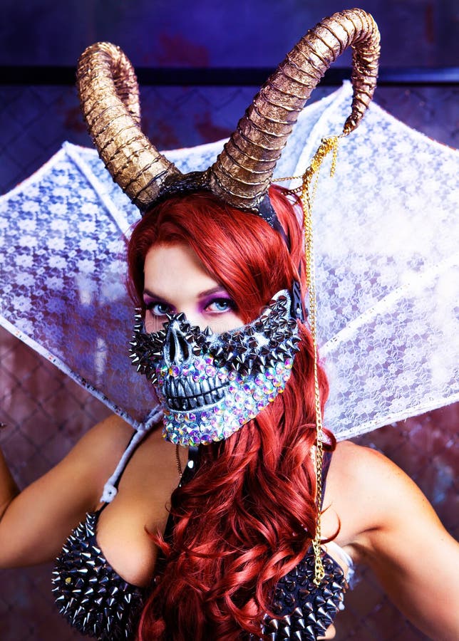 Beautiful young model wearing Halloween costume of leather , face mask and horns. Beautiful young model wearing Halloween costume of leather , face mask and horns