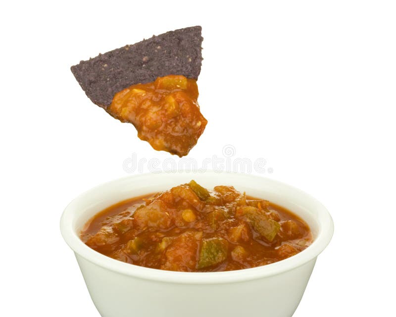 Image of blue corn tortilla chip dipped in bowl of chunky salsa isolated on white background. Image of blue corn tortilla chip dipped in bowl of chunky salsa isolated on white background.