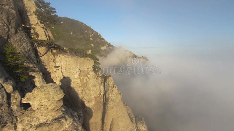 πτήση από βραχώδη βουνά με χαμηλά σύννεφα. σφαίρα. ακραία πτήση σε drone κοντά σε βραχώδεις πλαγιές βουνών με χαμηλωμένα