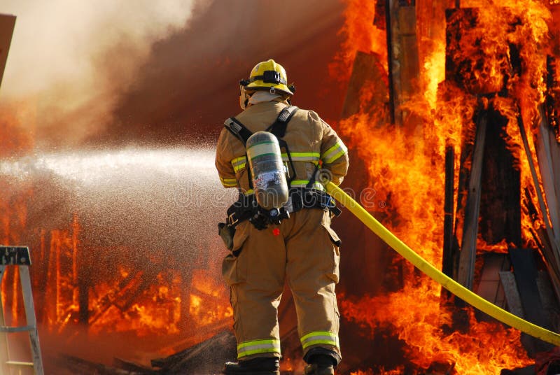 ROSEBURG, OR - SEPTEMBER 03: Single fire fighter sprays a straight steam into a fully involved shop fire off of Breezy Lane, September 03, 2011 in Roseburg, OR. ROSEBURG, OR - SEPTEMBER 03: Single fire fighter sprays a straight steam into a fully involved shop fire off of Breezy Lane, September 03, 2011 in Roseburg, OR