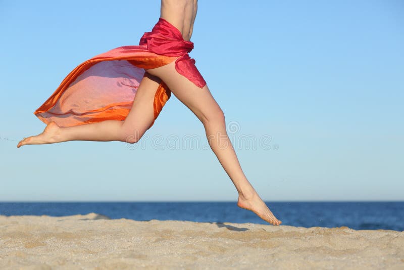 Πόδια γυναικών που πηδούν στην παραλία ευτυχή