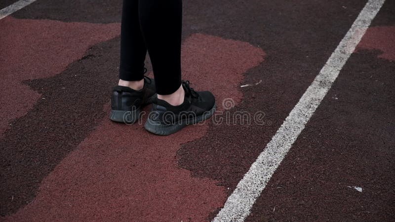 πόδια γυμνής γυναίκας δρομέα με μαύρα αθλητικά παπούτσια σε κοντινή απόσταση