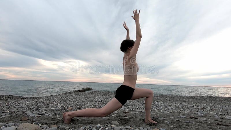 Πόδια τεντώματος γυναικών ικανότητας ή να κάνει lunges στην παραλία Θηλυκός αθλητής που κάνει τη χαλαρώνοντας άσκηση προς τη θάλα