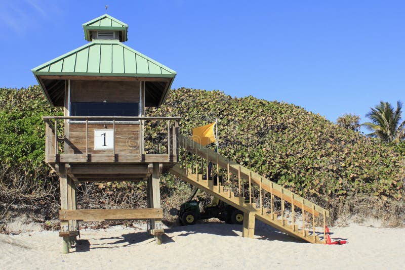 BOCA RATON, FLORIDA - FEBRUARY 1: A lifeguard tower displays a yellow flag warning people to exercise caution and stay near lifeguard station on February 1, 2013 in Boca Raton, Florida. BOCA RATON, FLORIDA - FEBRUARY 1: A lifeguard tower displays a yellow flag warning people to exercise caution and stay near lifeguard station on February 1, 2013 in Boca Raton, Florida.