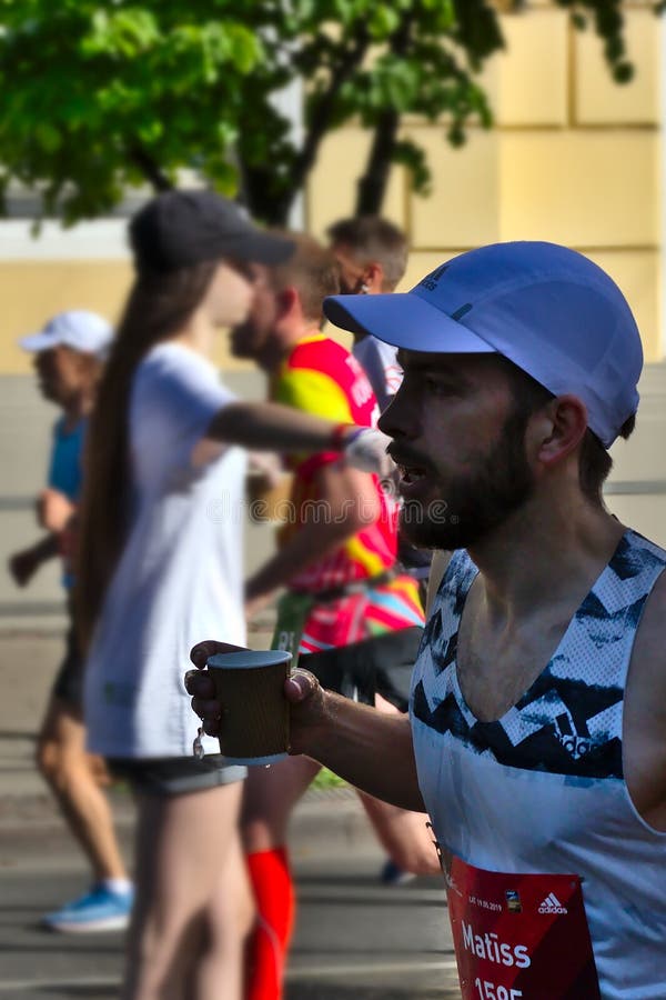 Ρήγα, Λετονία - 19 Μαΐου 2019: Γενειοφόρο άτομο που τρέχει με το φλυτζάνι στο χέρι του στοκ φωτογραφίες Ρήγα, Λετονία - 19 Μαΐου 2019: Γενειοφόρο άτομο που τρέχει με το φλυτζάνι στο χέρι του στοκ φωτογραφίες