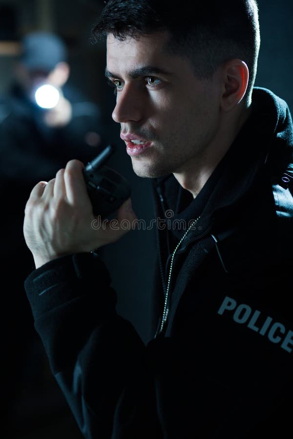 Portrait of a young police officer holding radio. Portrait of a young police officer holding radio