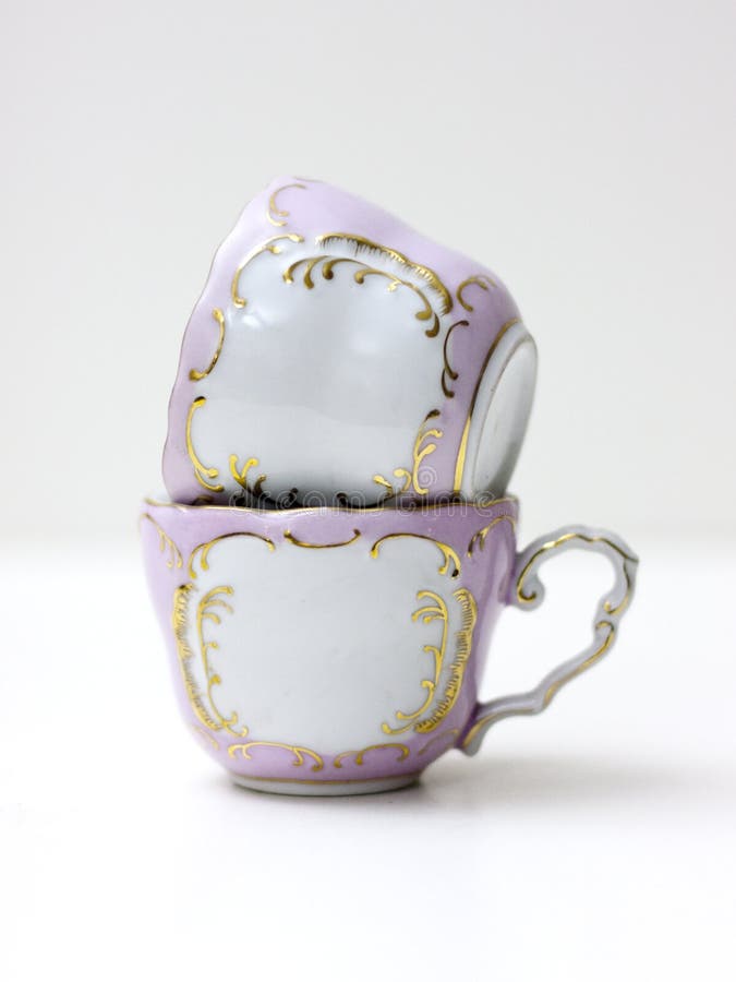 2 fancy tea cups in pink and blue on a white. 2 fancy tea cups in pink and blue on a white.