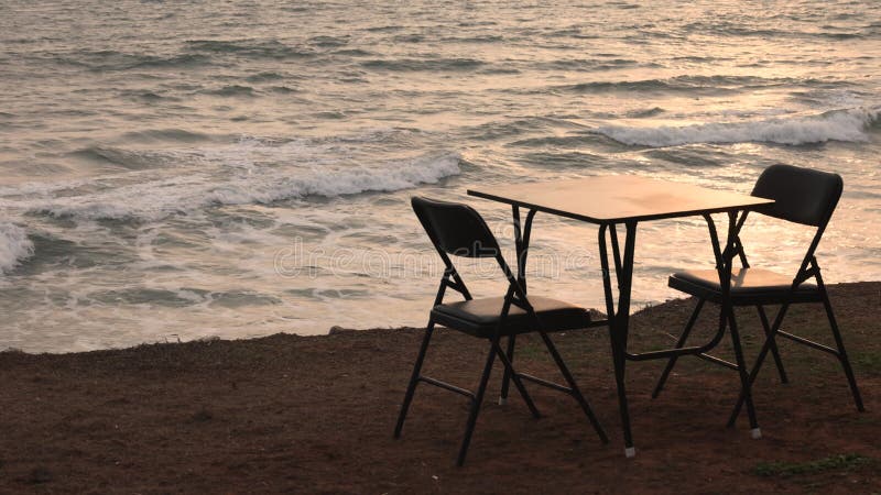 ρομαντικό ηλιοβασίλεμα στην παραλία σε ένα εξωτερικό καφέ τροπικού νησιού στην παραλία απόθεμα βίντεο