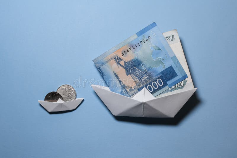 ρουλεμάν σε χάρτινες βάρκες σε μπλε φόντο την έννοια της συσσώρευσης πλωτών ρούβλων στη θάλασσα στοκ φωτογραφία