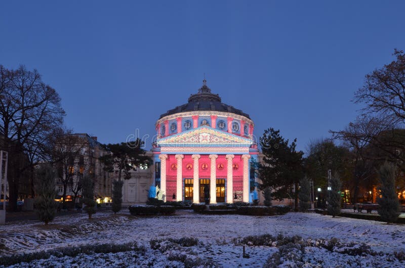 Bucharest, Romania - November 30, 2018: Romanian Athenaeum painted by light projections in celebration of 100 years of Greater Union Day. Bucharest, Romania - November 30, 2018: Romanian Athenaeum painted by light projections in celebration of 100 years of Greater Union Day.