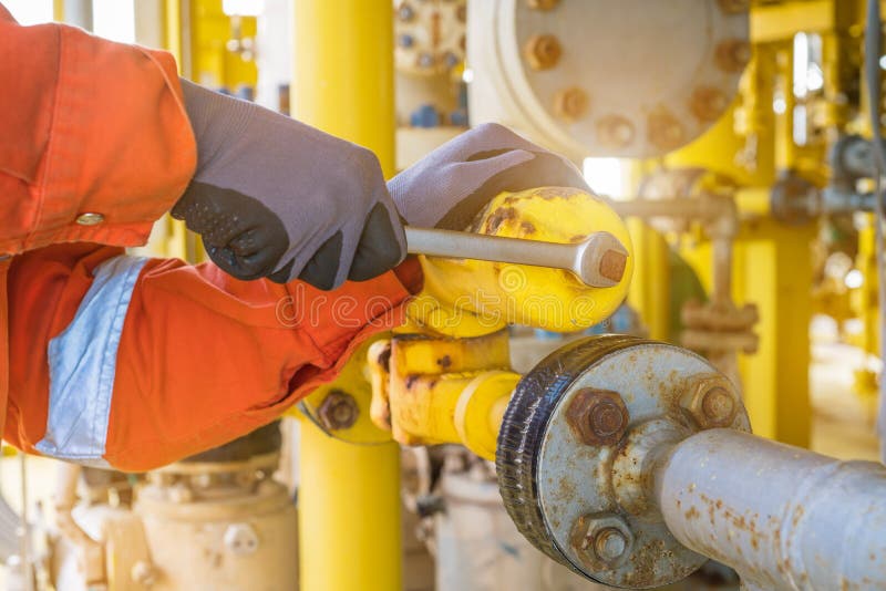 The production operator adjusting pressure regulator of instrument gas supply system, offshore oil rig worker operating on control system at oil and gas wellhead remote platform. The production operator adjusting pressure regulator of instrument gas supply system, offshore oil rig worker operating on control system at oil and gas wellhead remote platform.