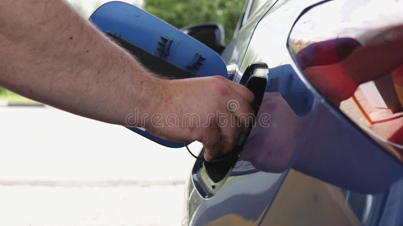 ρωσία αύγουστος 23 2021 : πλήρωση του αυτοκινήτου σε βενζινάδικο. κλειστό αρσενικό χέρι βγάζει έξω το γέμισμα του ακροφυσίου φιλμ μικρού μήκους